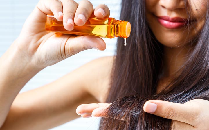 Woman applying hair oil